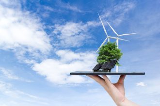 Ecological system solar energy in the city on the hand holding t Ecological system solar energy in the city on the hand holding the tablet